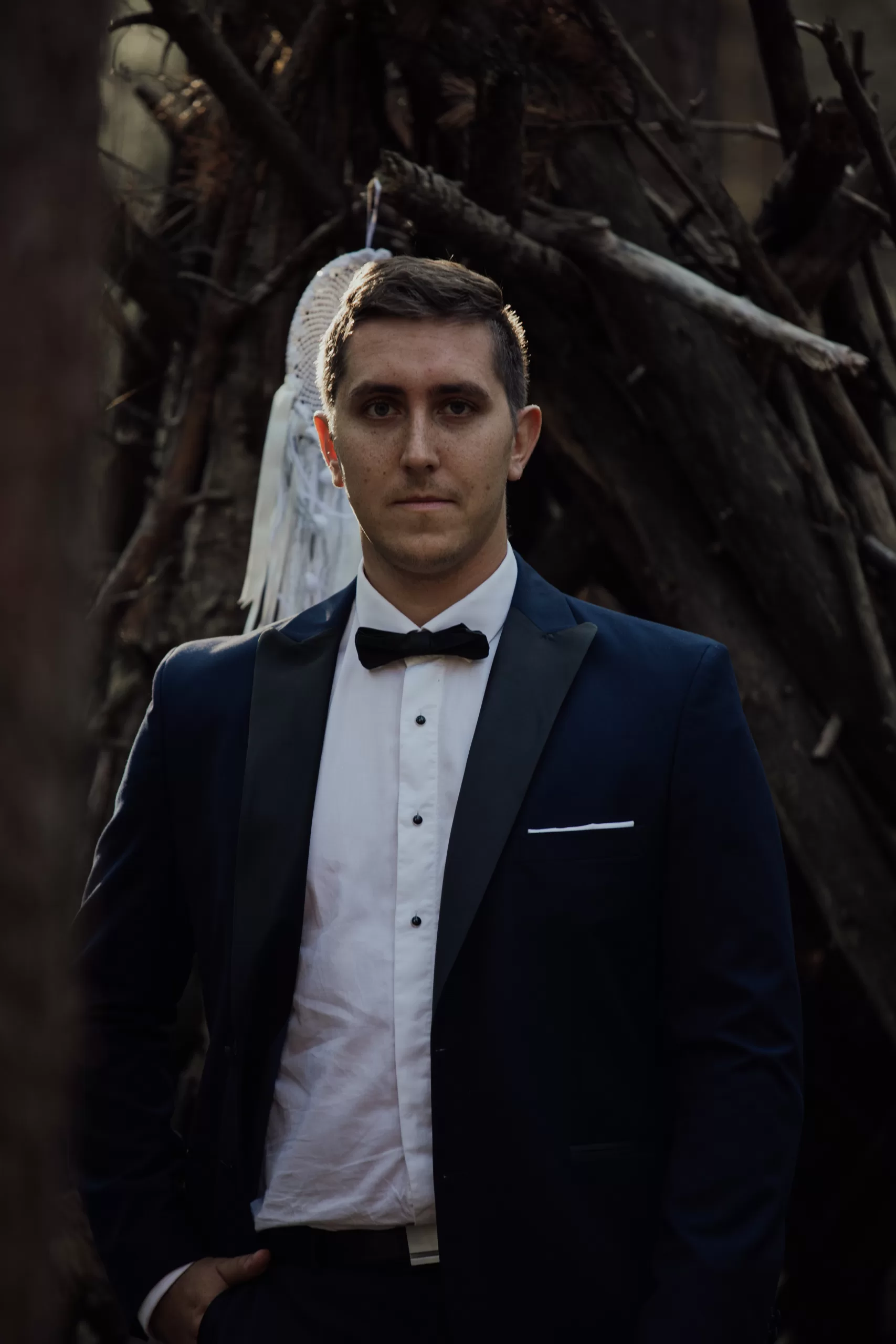 EN: Portrait of groom in black suit in forest wedding in Lofoten DE: Porträt des Bräutigams im schwarzen Anzug – Hochzeitsfotografie in Lofoten ZH: 新郎黑色西装森林婚礼肖像 – 洛福腾婚礼摄影师 TH: ภาพพอร์เทรตเจ้าบ่าวชุดดำในป่า – ช่างภาพงานแต่งโลโฟเทน