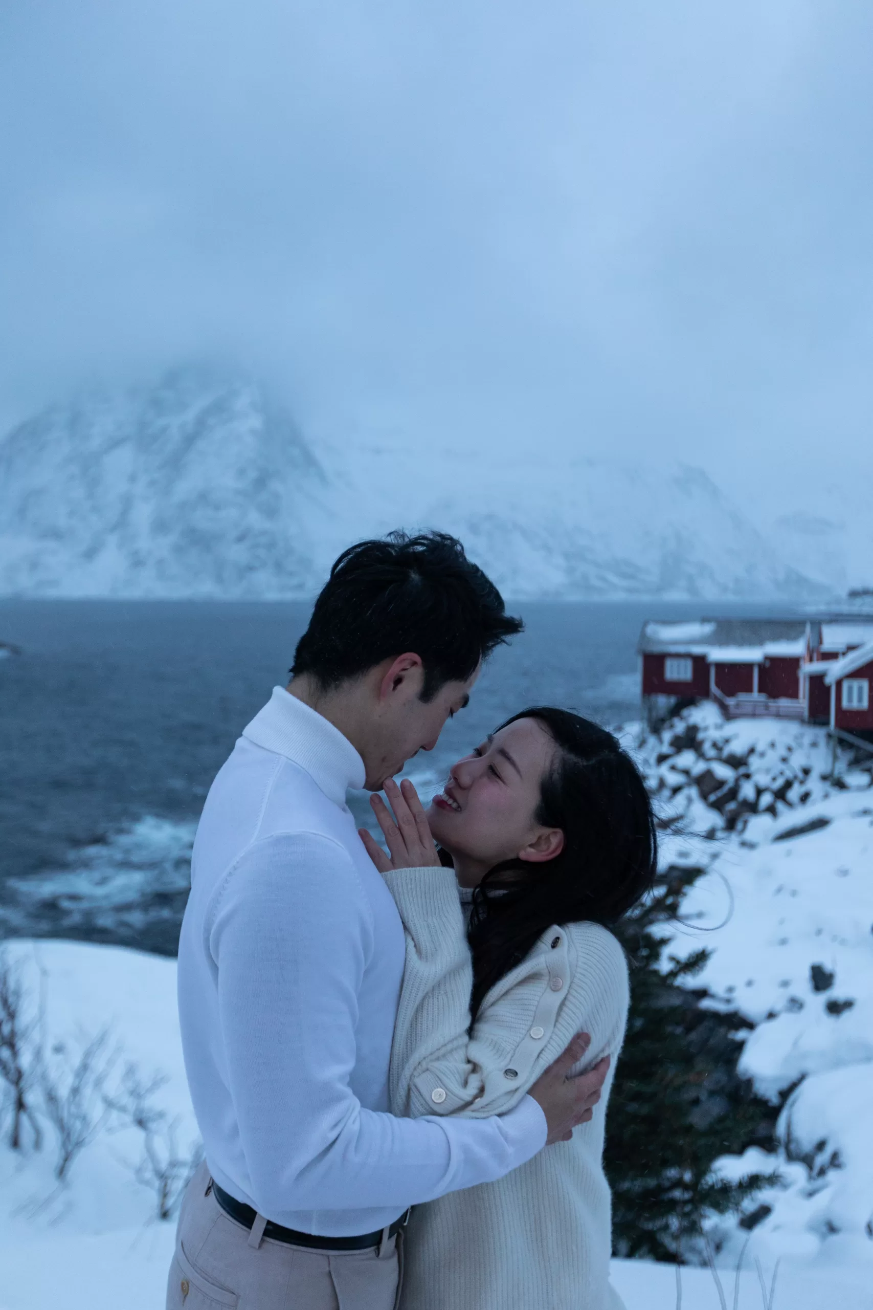 English: Couple hugging during a winter engagement photo session in Lofoten – Wedding photographer Lofoten Chinese (中文): 情侣在洛弗敦冬季订婚摄影中拥抱 – 洛弗敦婚礼摄影师 Thai (ไทย): คู่รักกอดกันในเซสชั่นถ่ายภาพหมั้นฤดูหนาวที่โลโฟเทน – ช่างภาพแต่งงานโลโฟเทน German (Deutsch): Paar umarmt sich bei einem Winter-Verlobungsshooting in den Lofoten – Hochzeitsfotograf Lofoten