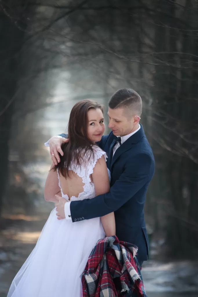Winter wedding couple embracing in Nordic forest — Wedding photographer Lofoten 冬季婚礼情侣在北欧森林中拥抱 — 洛福敦婚礼摄影师 คู่แต่งงานฤดูหนาวโอบกอดกันในป่าแบบนอร์ดิก — ช่างภาพงานแต่งงาน โลโฟเทน Winterhochzeitspaar umarmt sich im nordischen Wald — Hochzeitsfotograf Lofoten